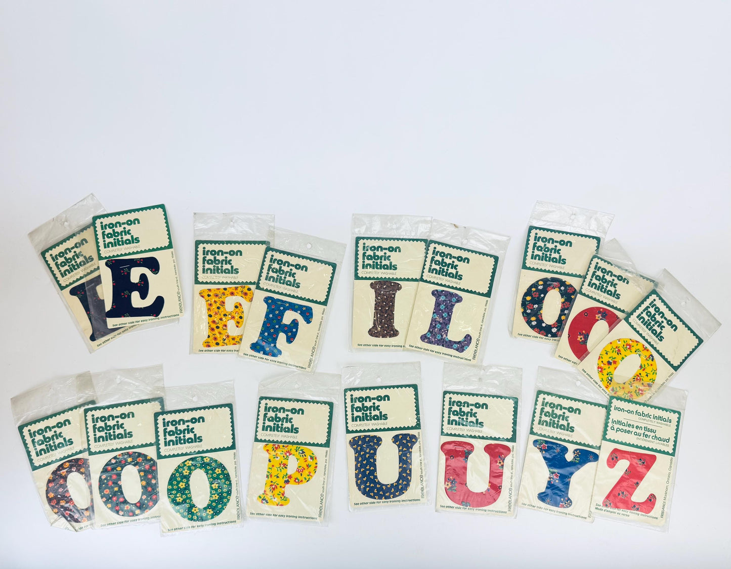 Set of iron-on fabric initials in various colors on a white background