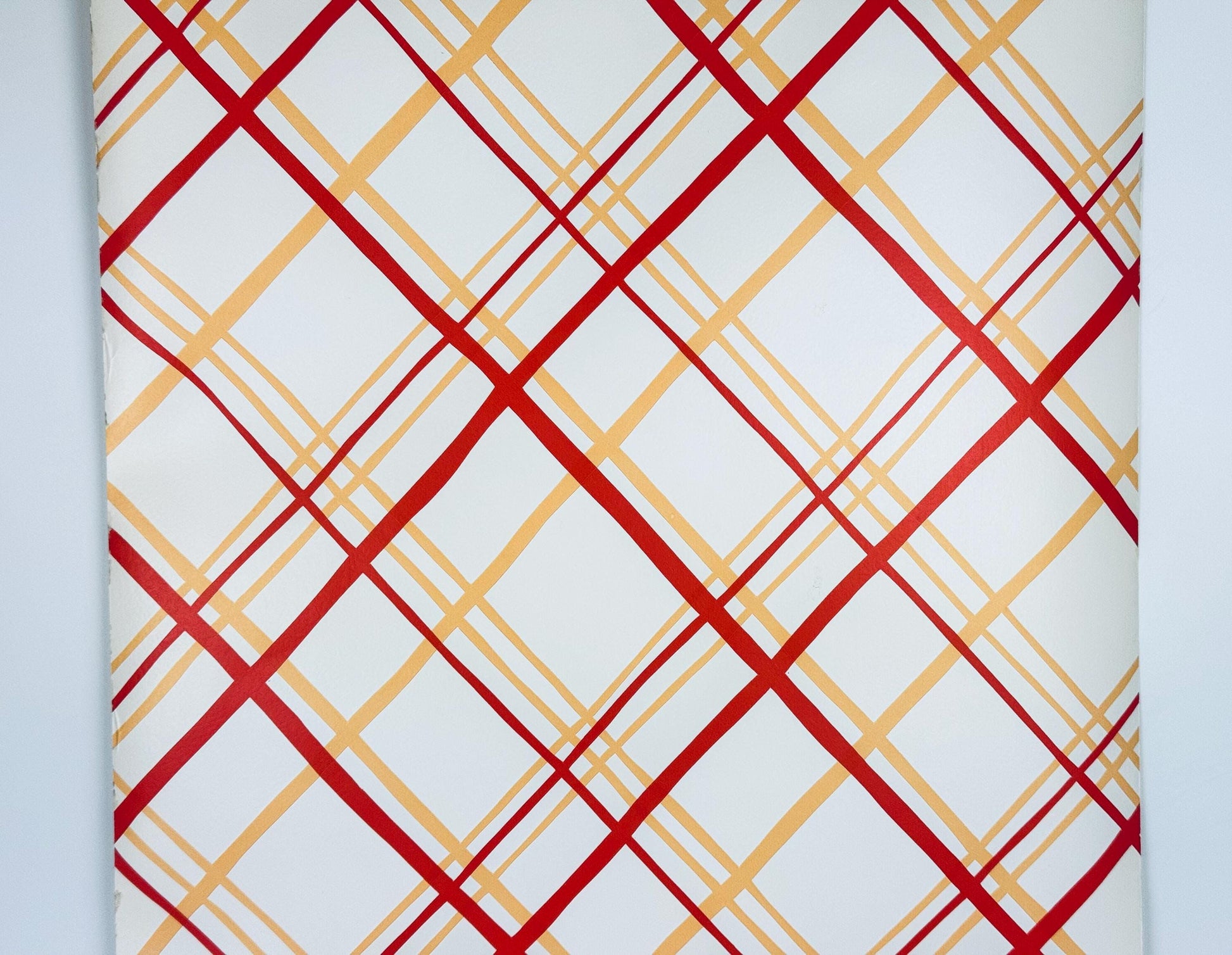 Patterned paper with red and gold geometric design on a white background