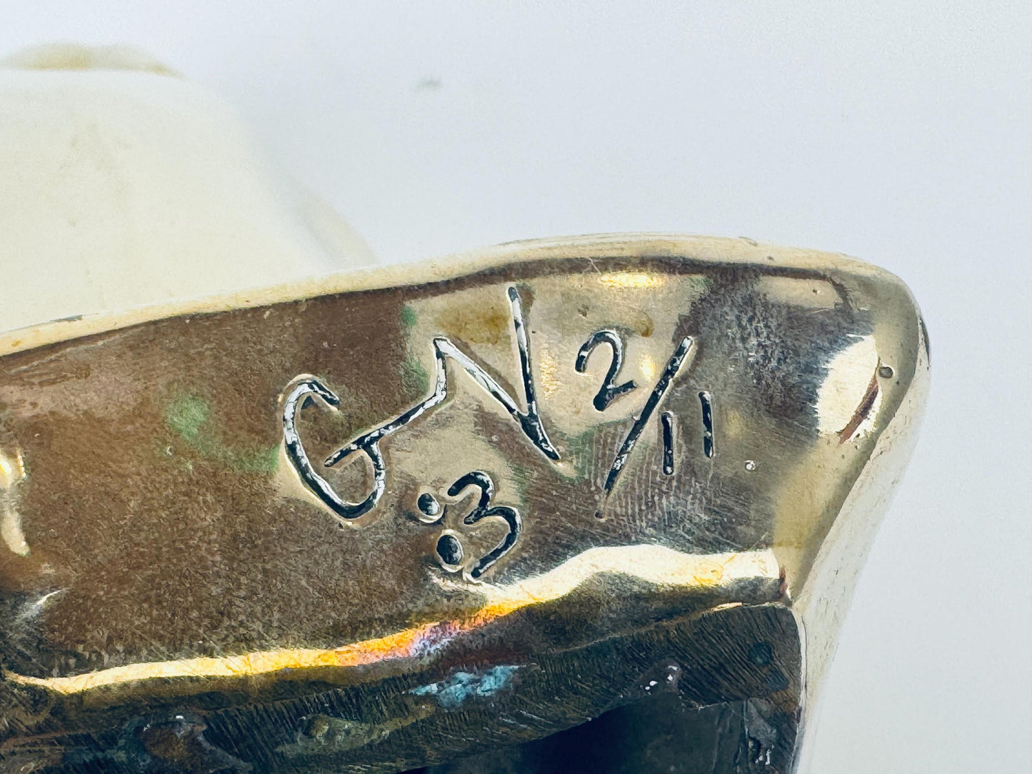 Close-up of a gold object with engraved text on a white background