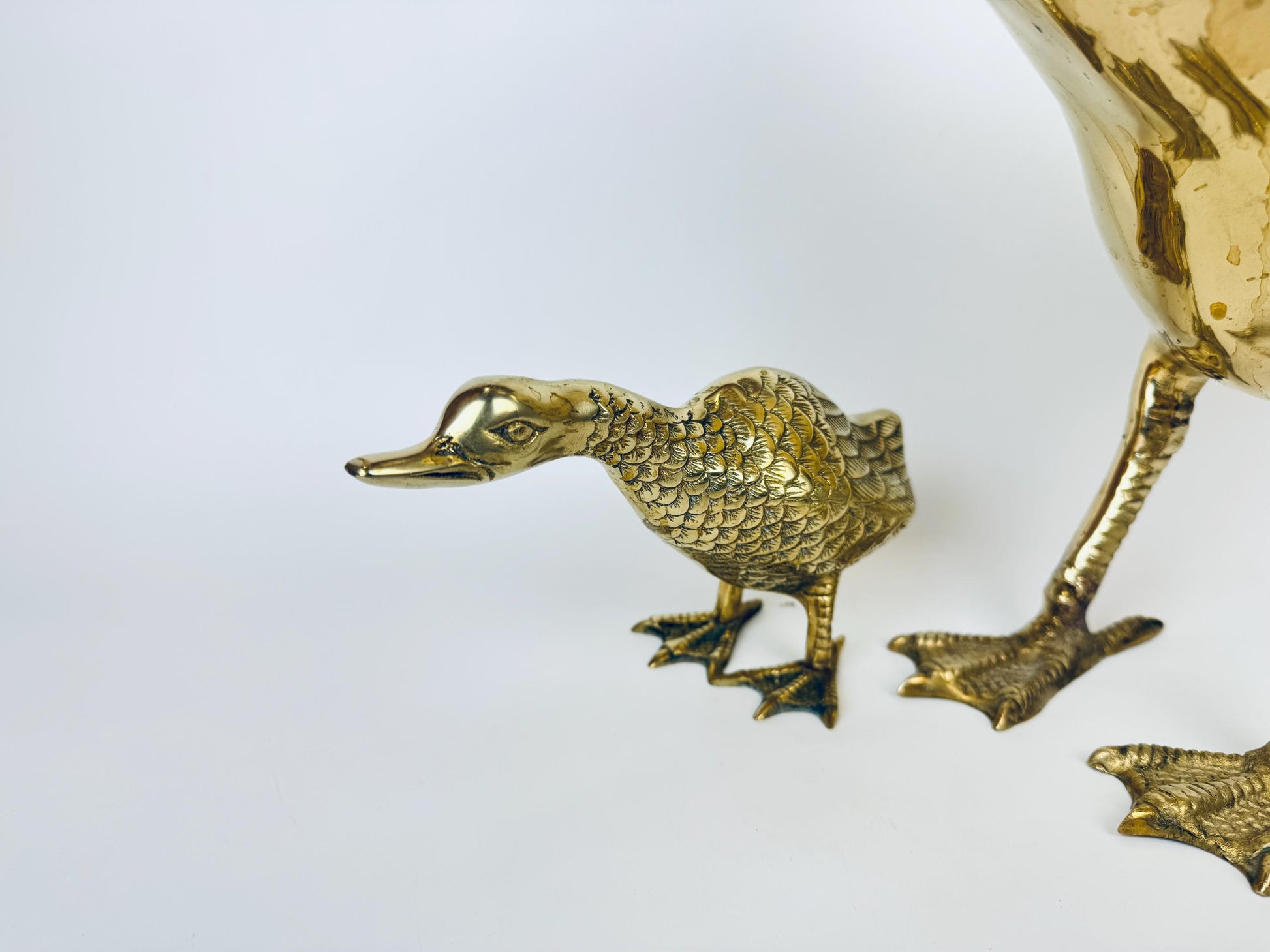 Brass duck-shaped object on a white background
