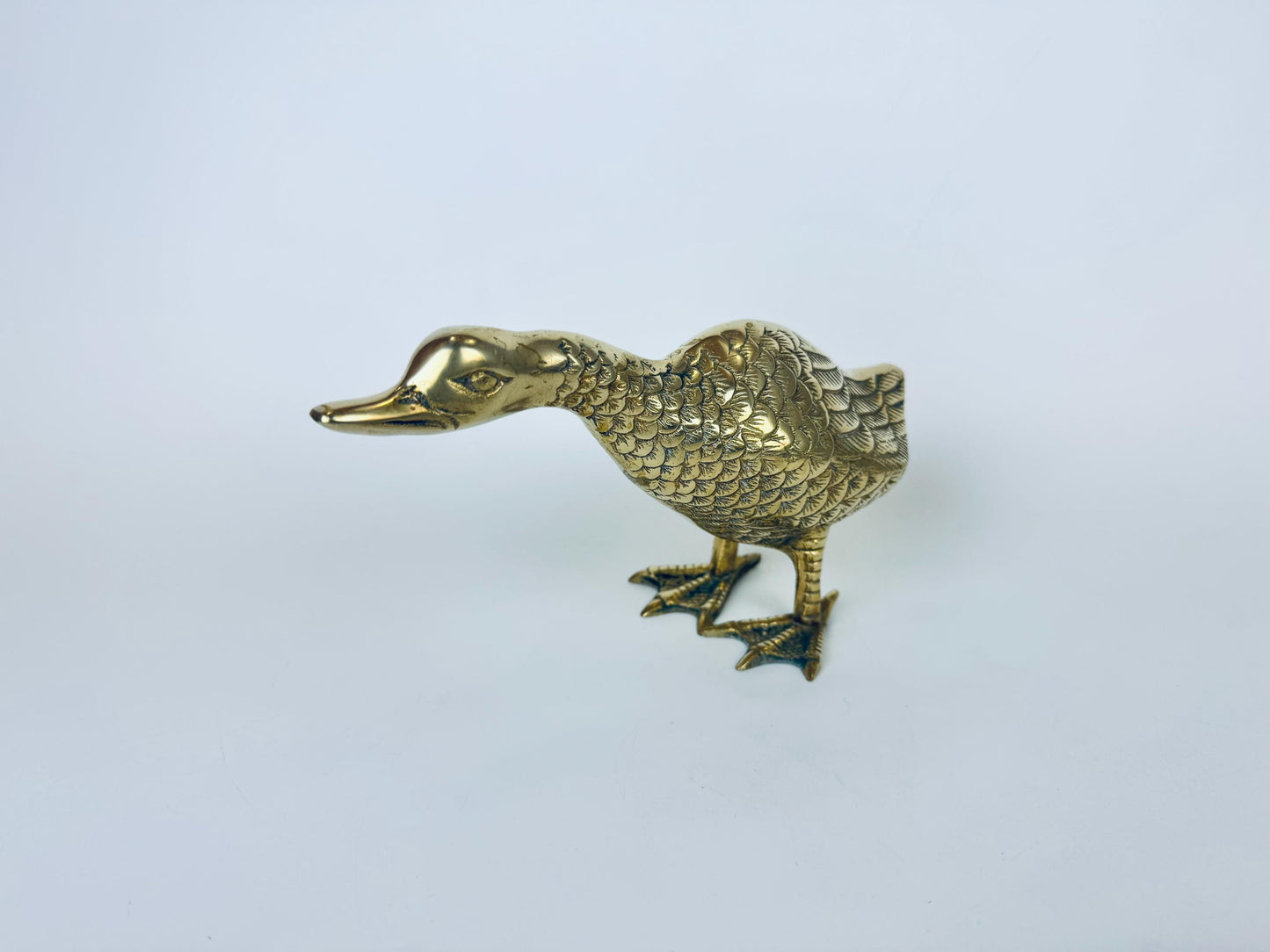 Gold duck-shaped object on a white background