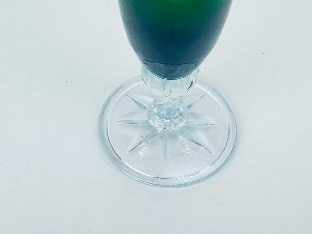 Clear glass with green liquid on a white background