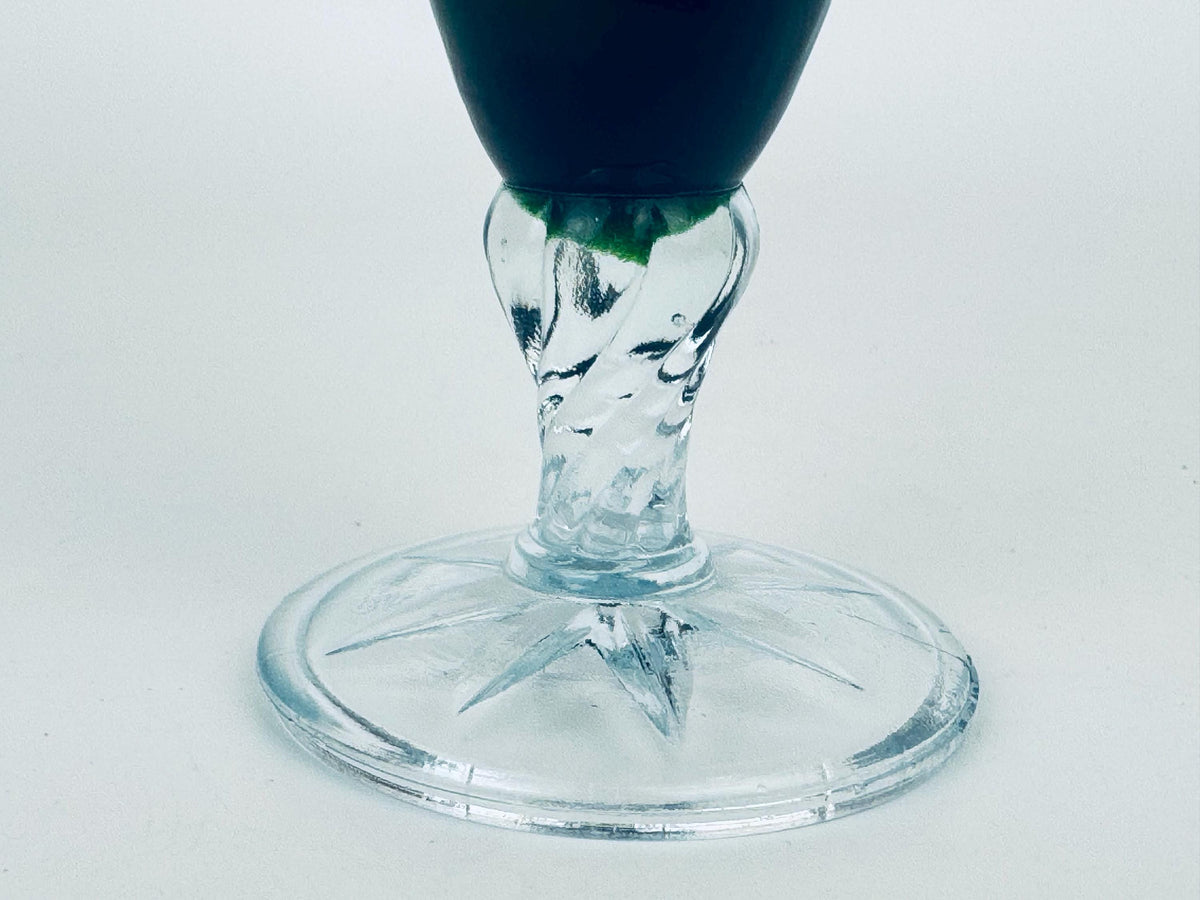 Clear glass object with a textured base on a white background