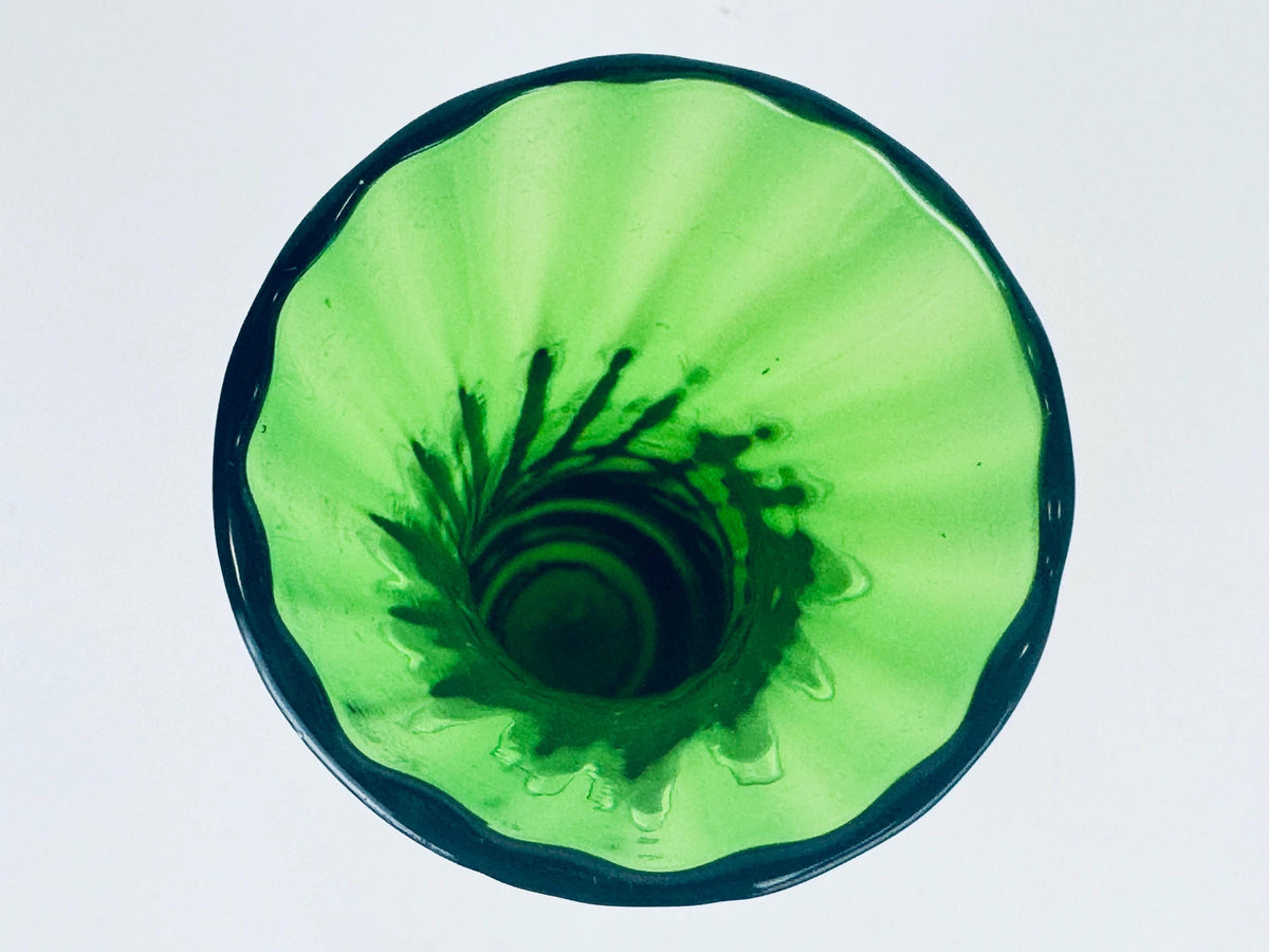 Green glass vase with a textured surface on a white background