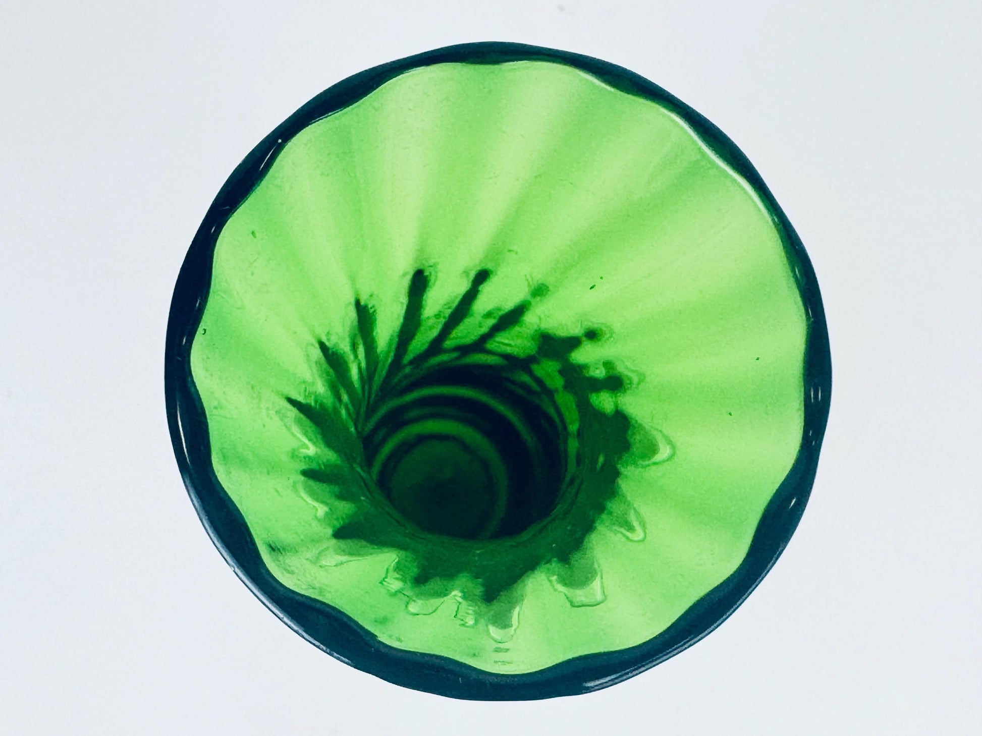 Green glass vase with a textured surface on a white background