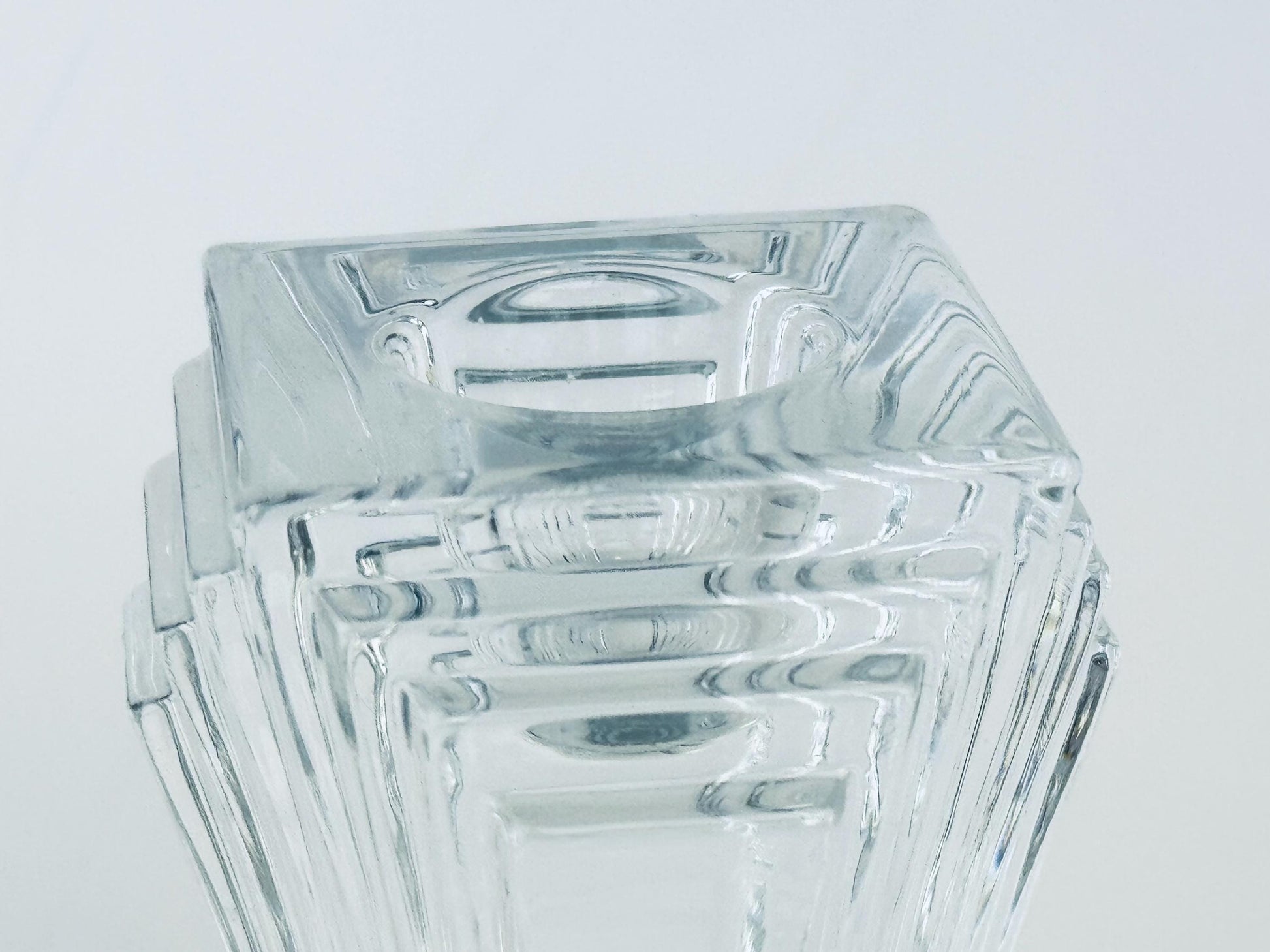 Stack of clear glass square bowls on a light gray background