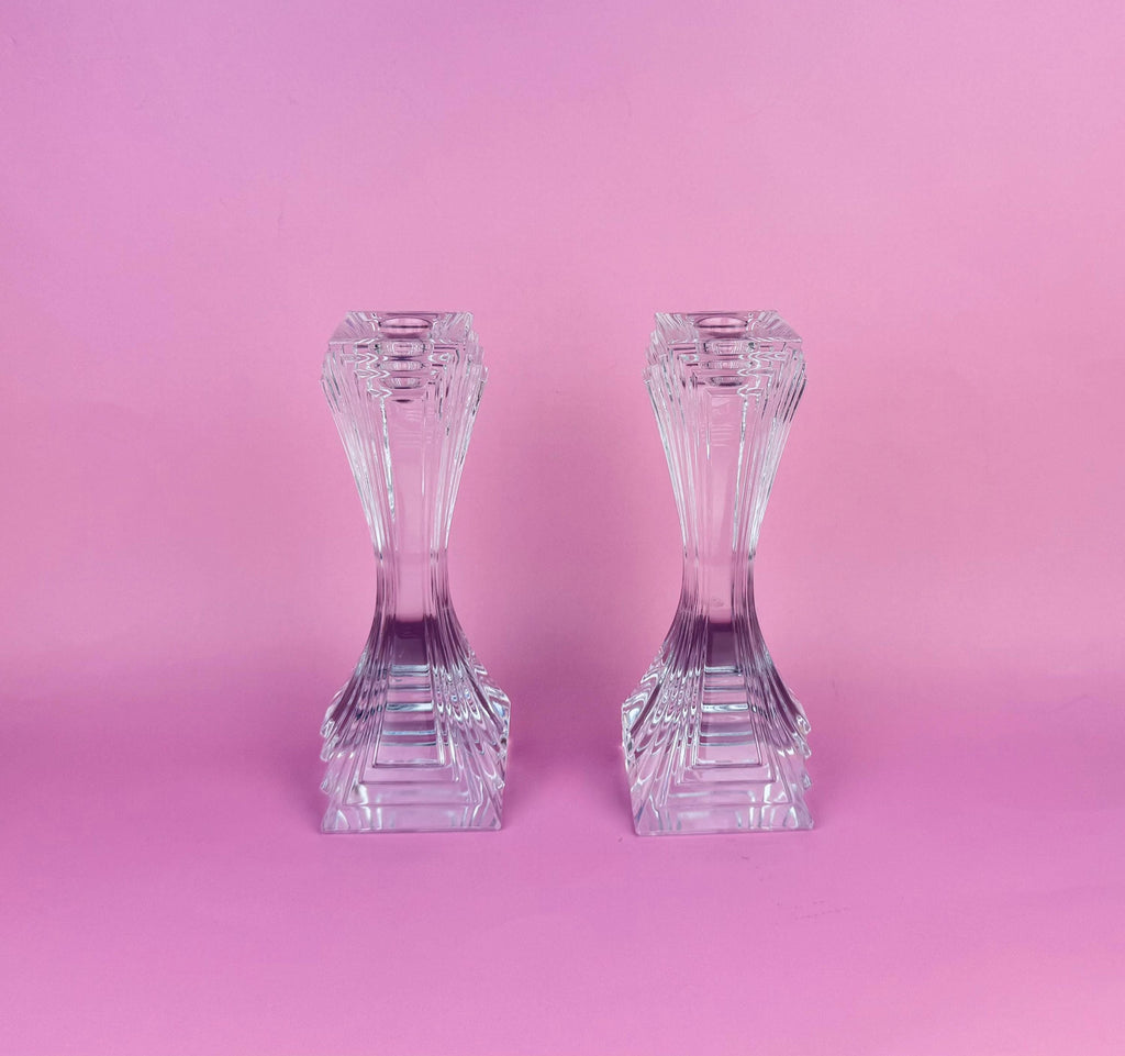 Two crystal candle holders on a pink background
