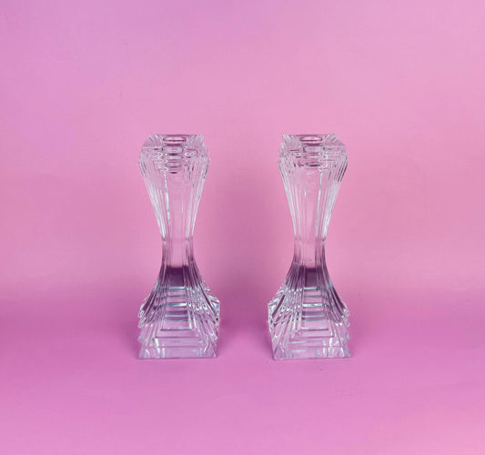 Two crystal candle holders on a pink background
