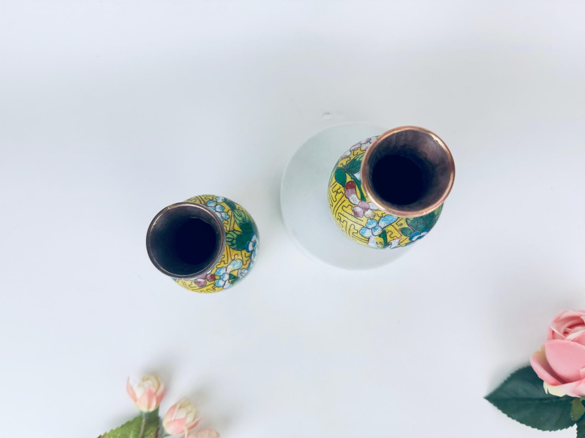Two decorative vases with floral patterns on a white background