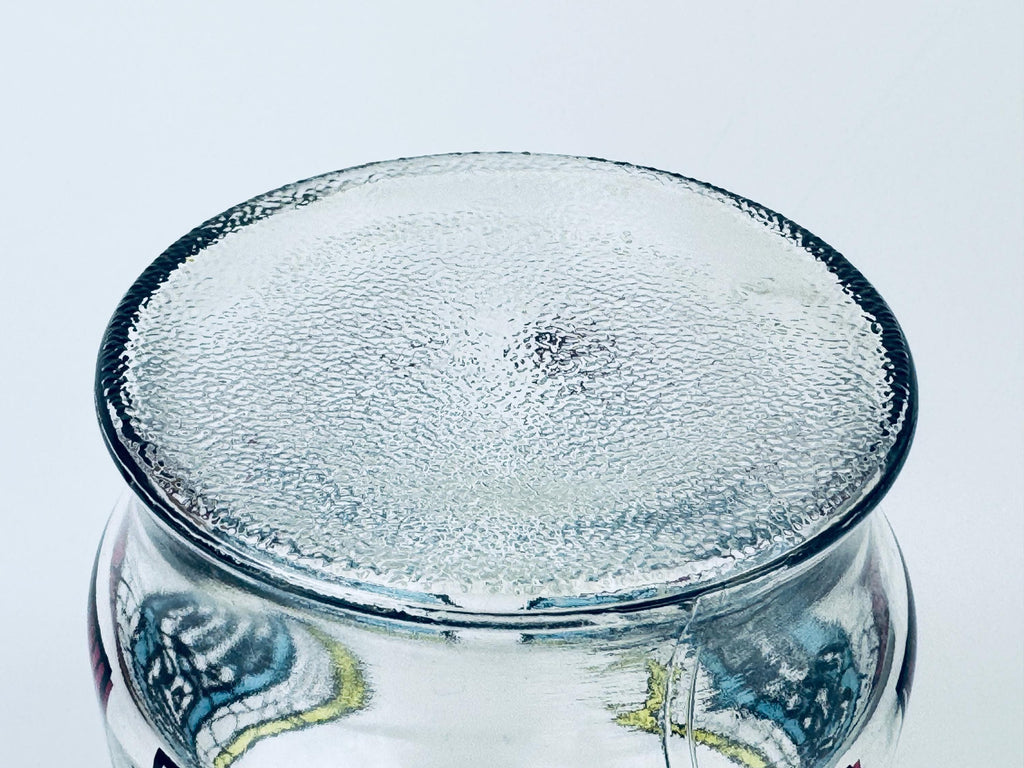 Clear glass jar with decorative bottom on a white background