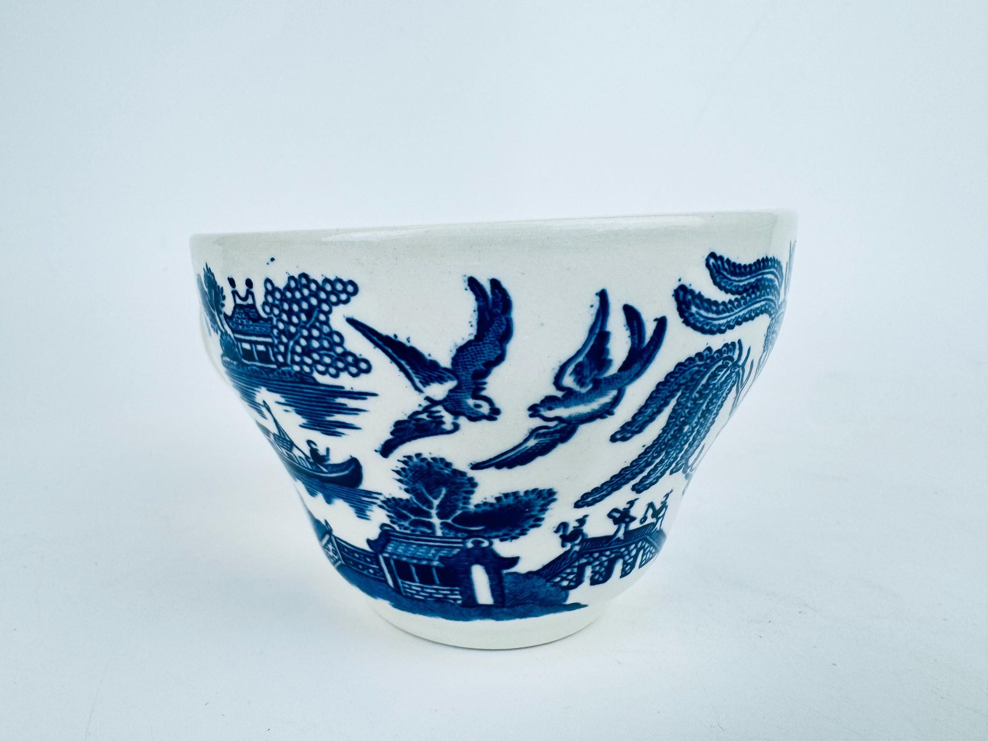 Ceramic cup with blue floral design on a white background