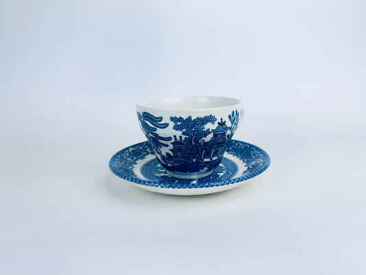 Blue and white ceramic cup and saucer on a light gray background