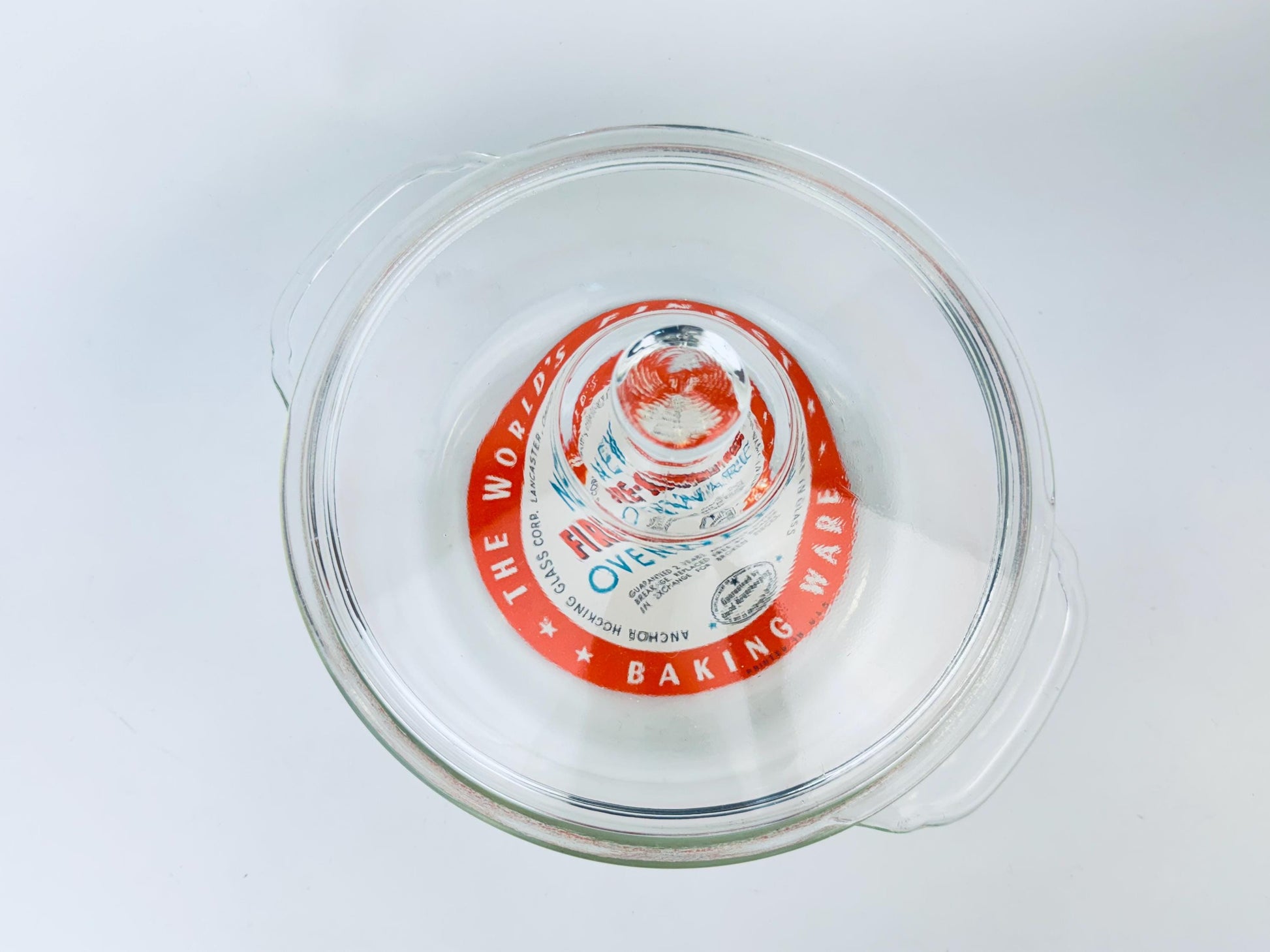 Glass lid with a red label on a white background