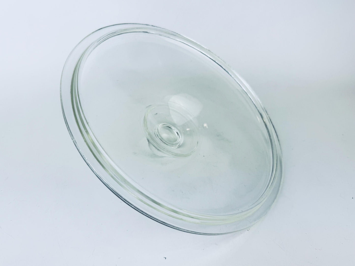 Clear glass pie dish lid on a white background