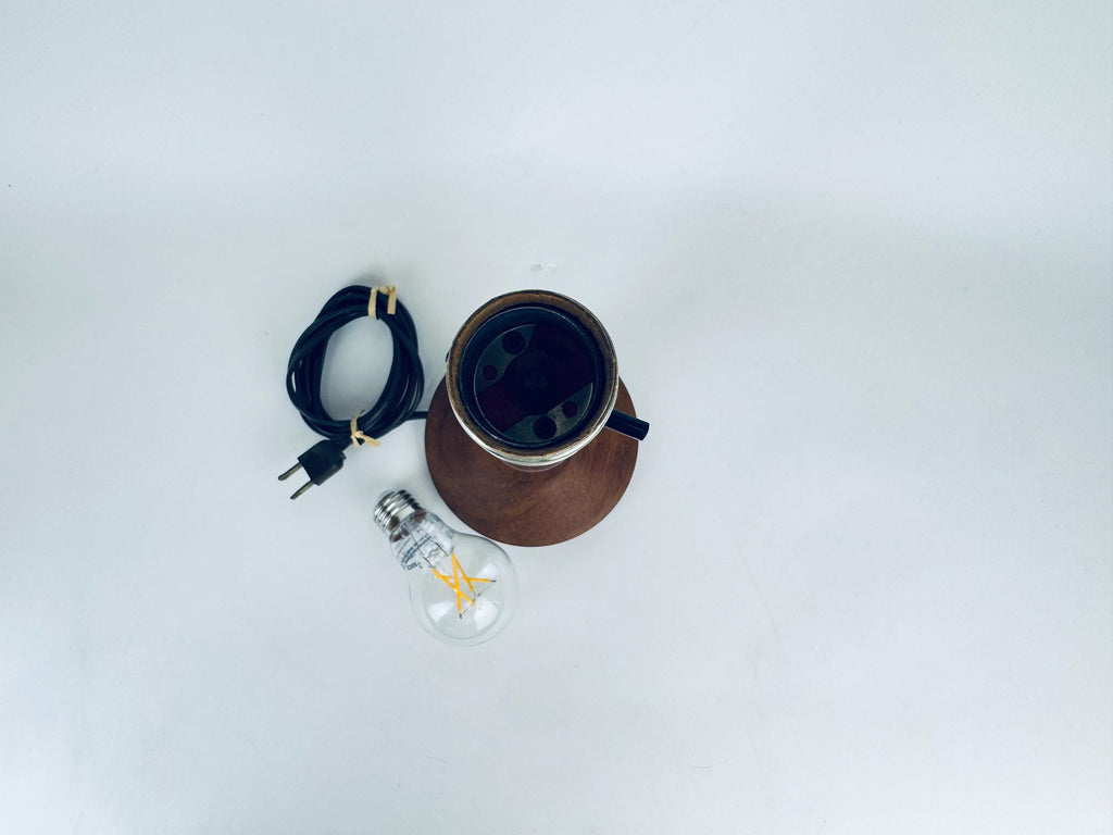Wooden lamp with a light bulb and plug on a white background