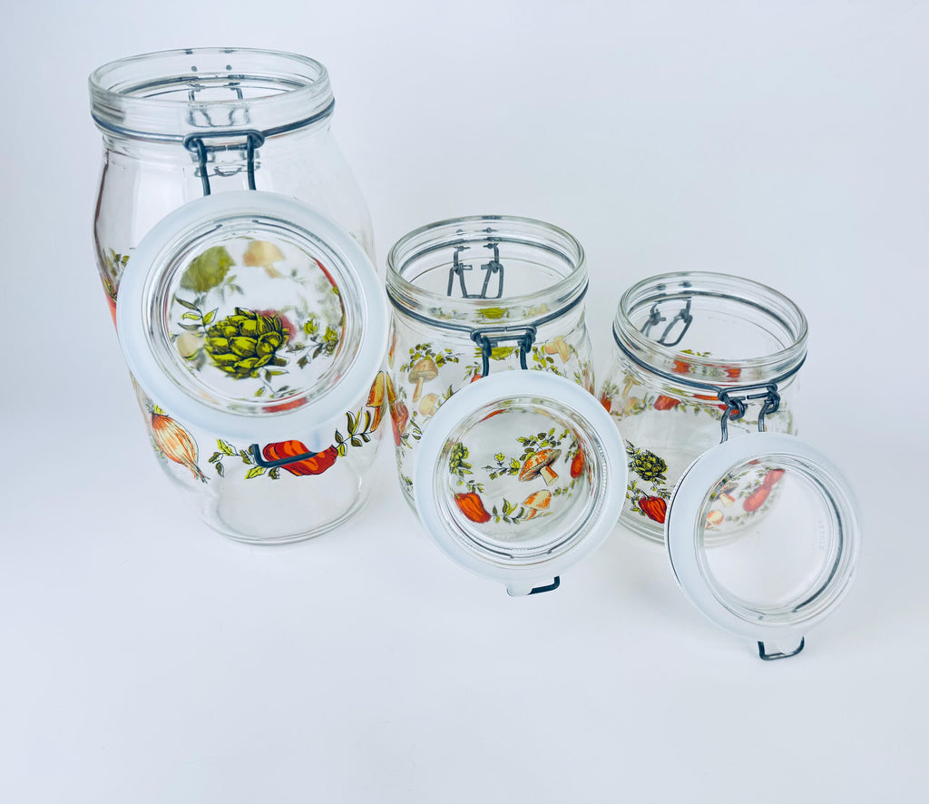 Set of glass jars with floral designs on a white background