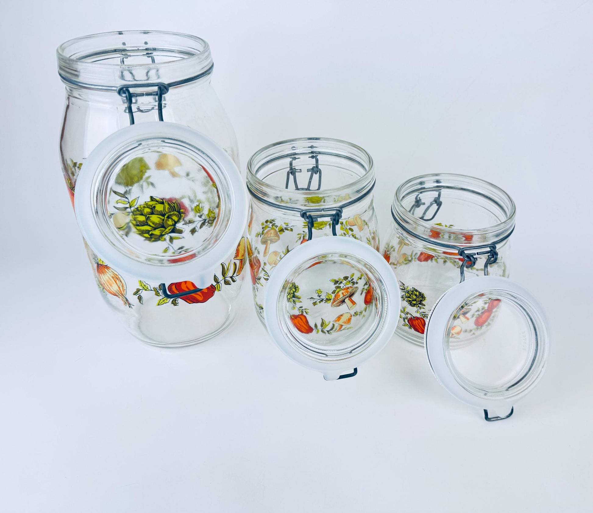 Set of glass jars with floral designs on a white background