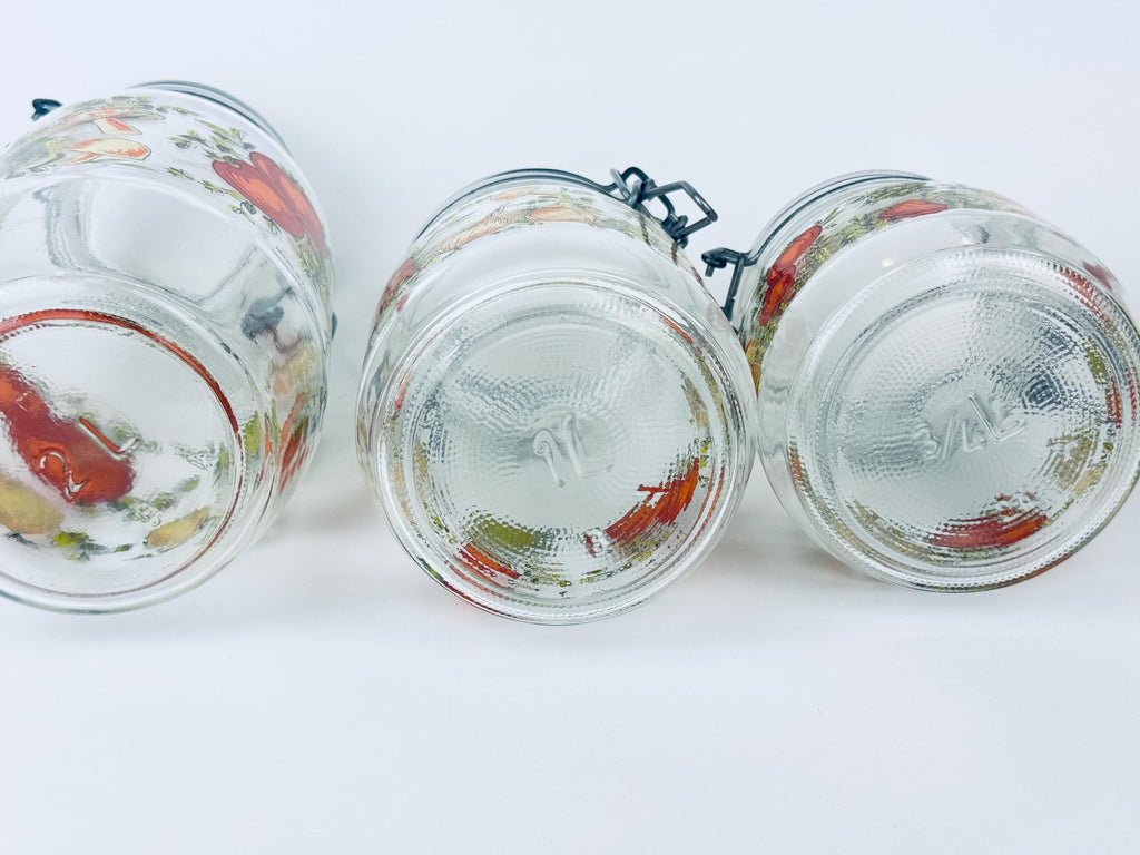 Three glass jars with decorative lids on a white background