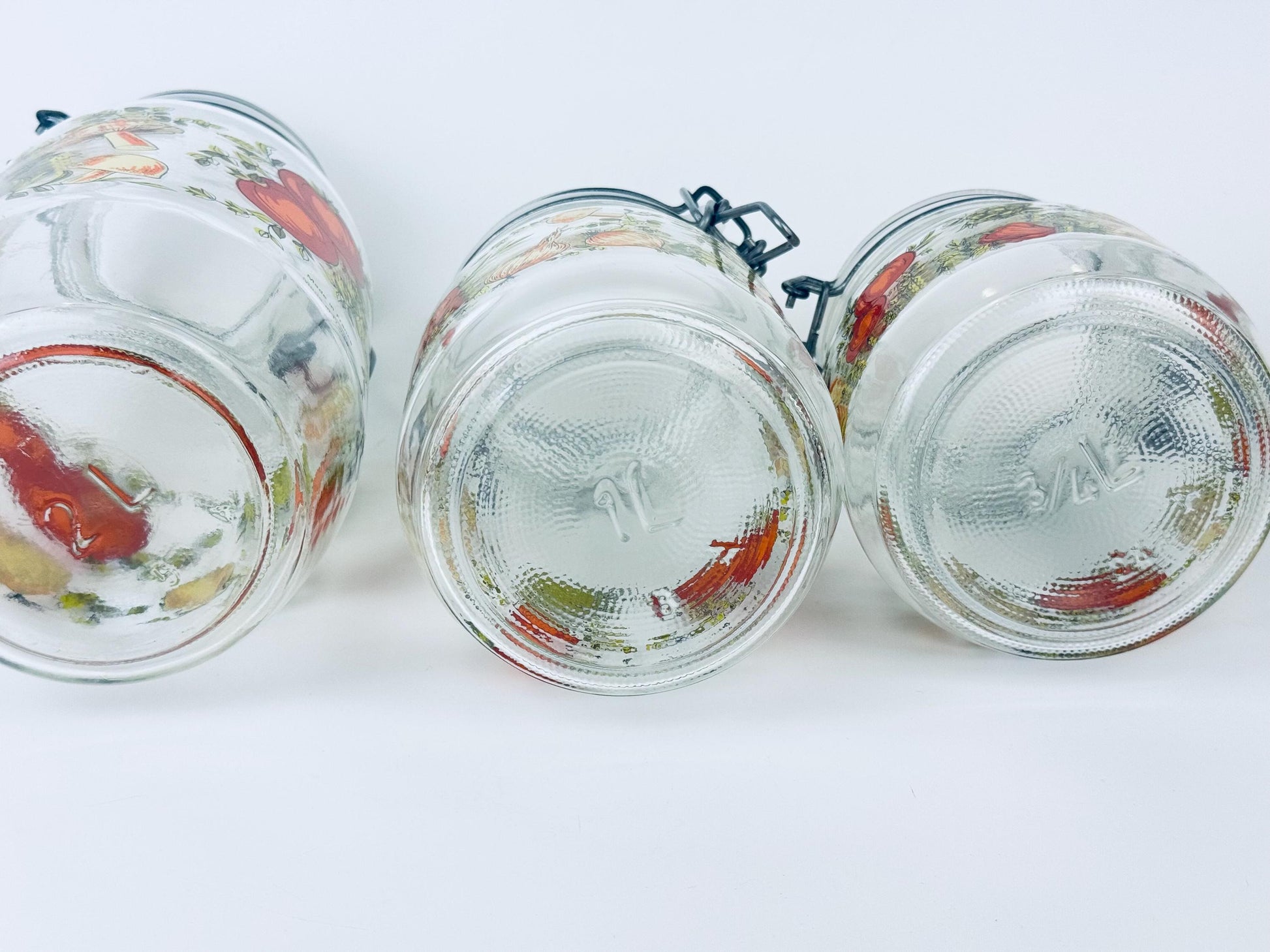 Three glass jars with decorative lids on a white background