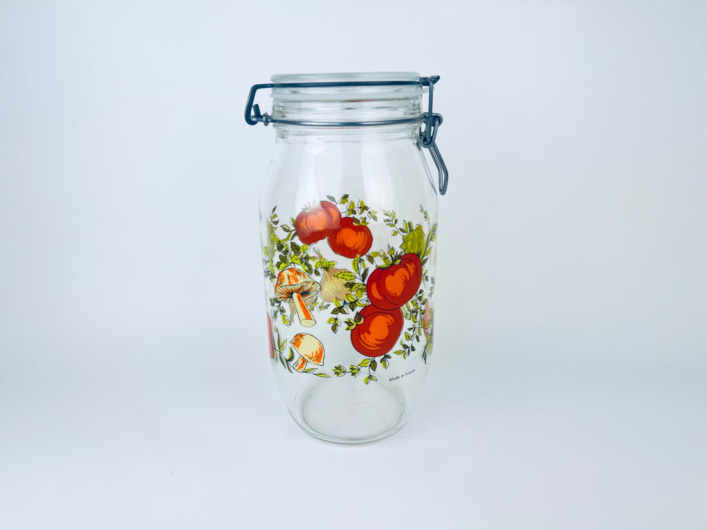 Glass jar with floral and vegetable design on a white background