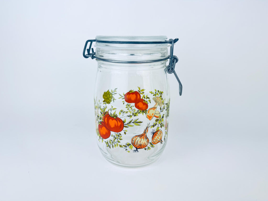 Glass jar with floral and vegetable design on a white background