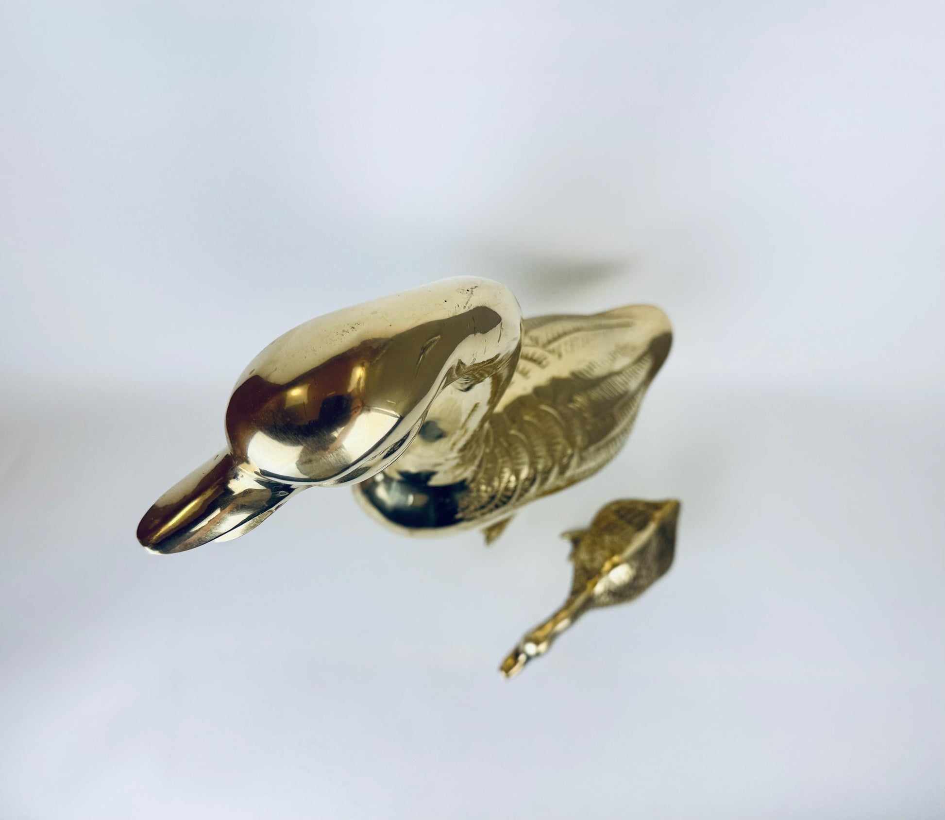 Gold duck-shaped object on a light gray background