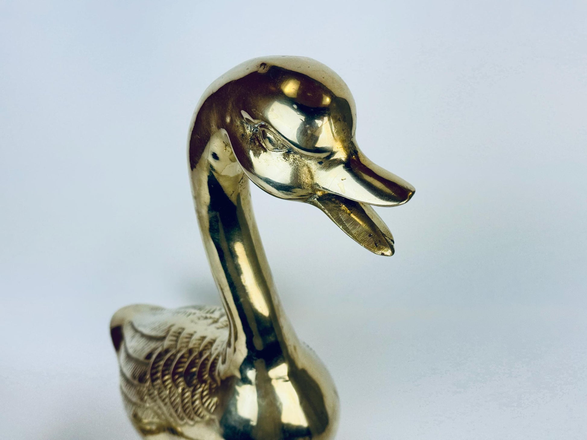 Gold duck-shaped object on a light gray background