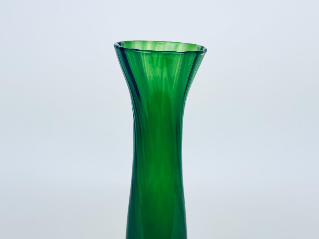 Green glass vase on a light gray background