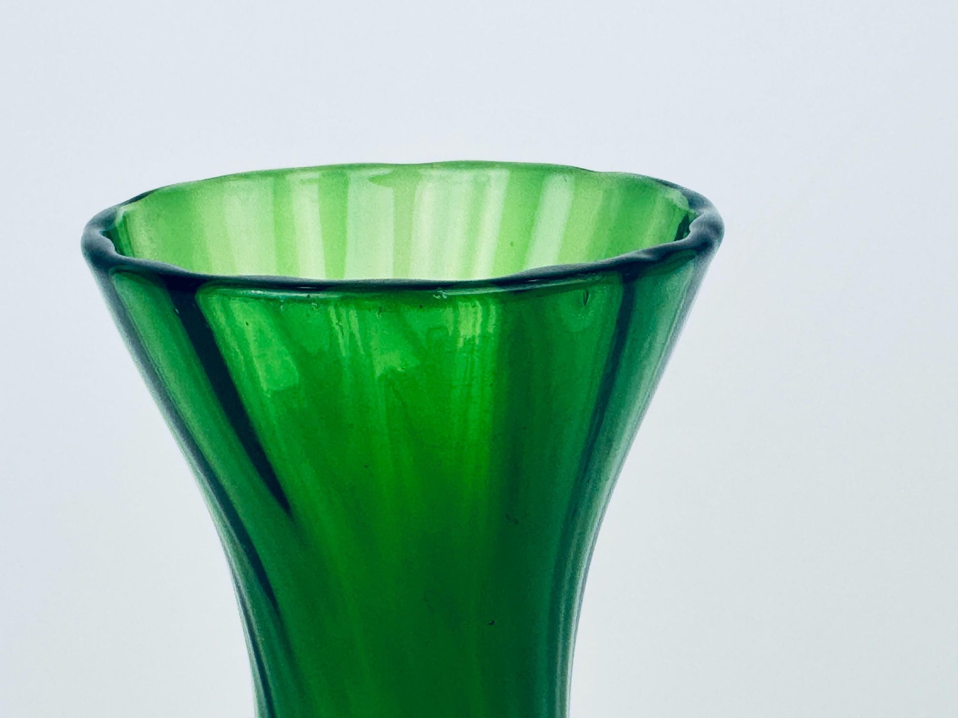 Green glass vase on a light gray background
