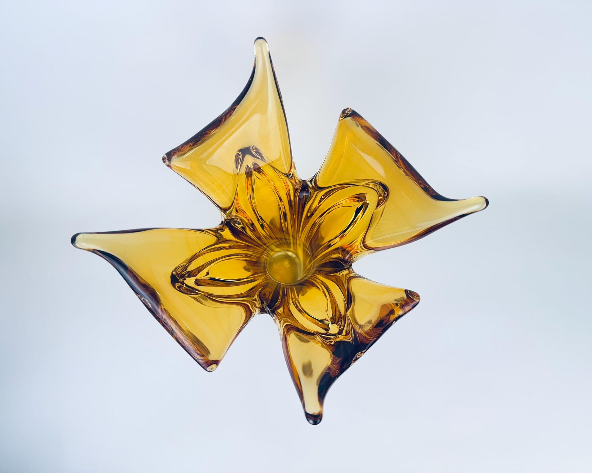 Yellow glass star-shaped object on a light gray background