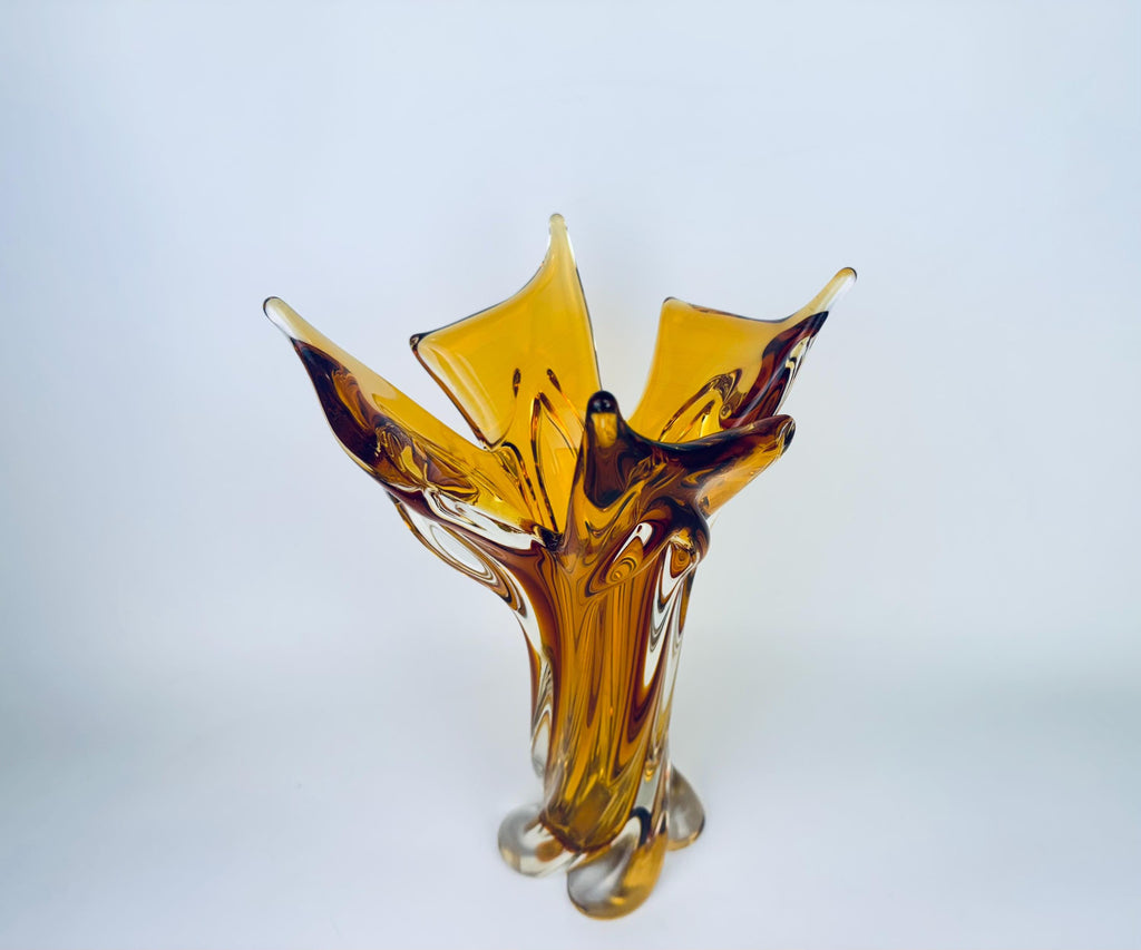 Amber glass vase with a unique design on a light gray background