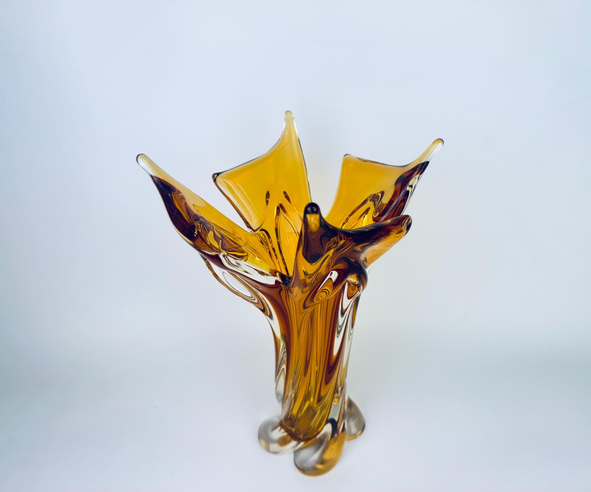 Amber glass vase with a unique design on a light gray background