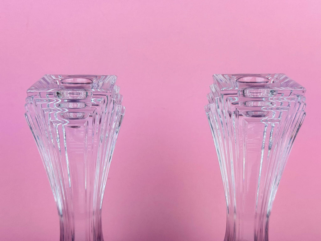 Two clear glass vases on a pink background