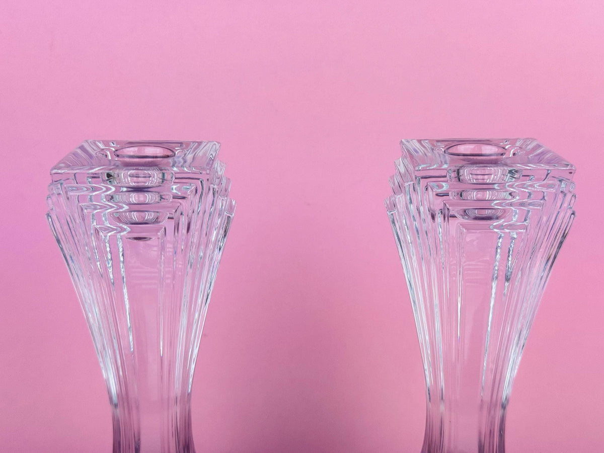Two clear glass vases on a pink background