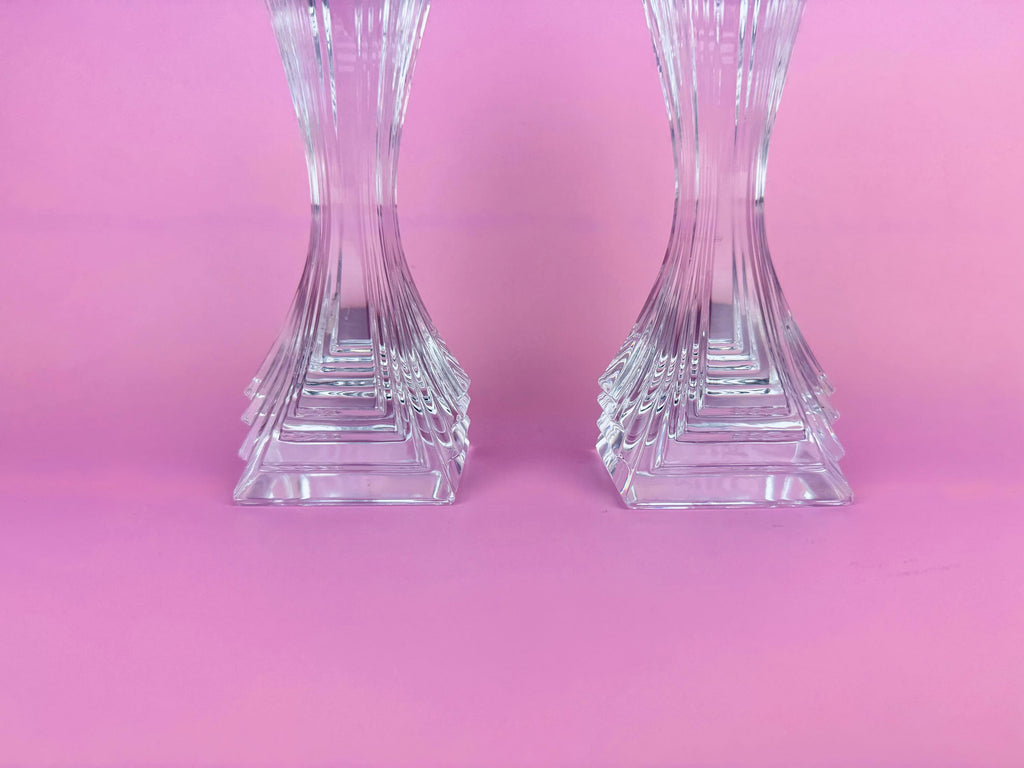 Two crystal candle holders on a pink background