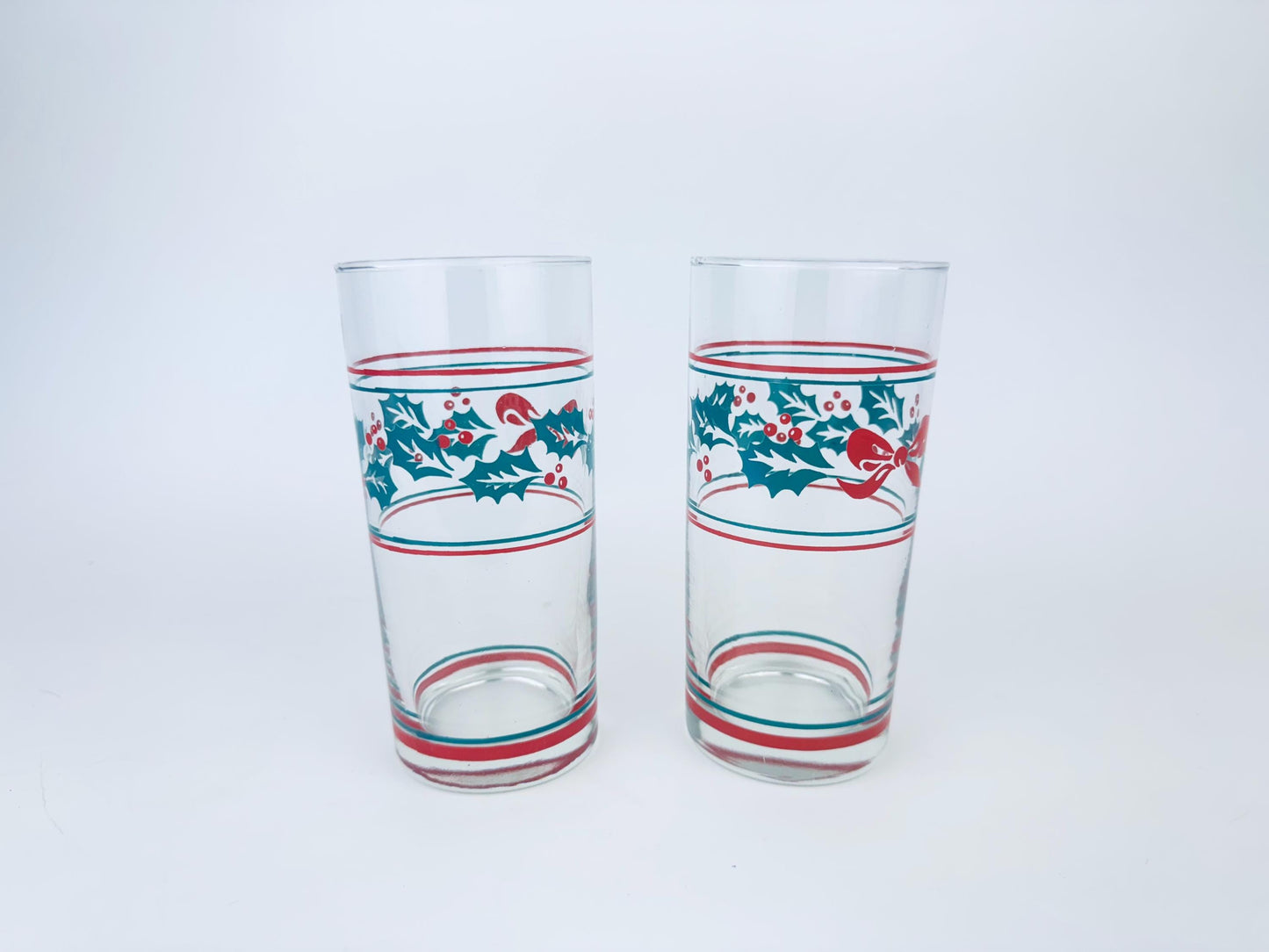 Two glass tumblers with festive designs on a white background