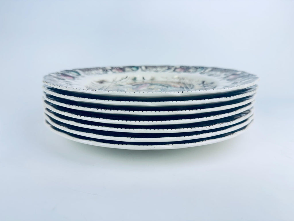 Stack of ceramic plates with brown and beige design on a light gray background