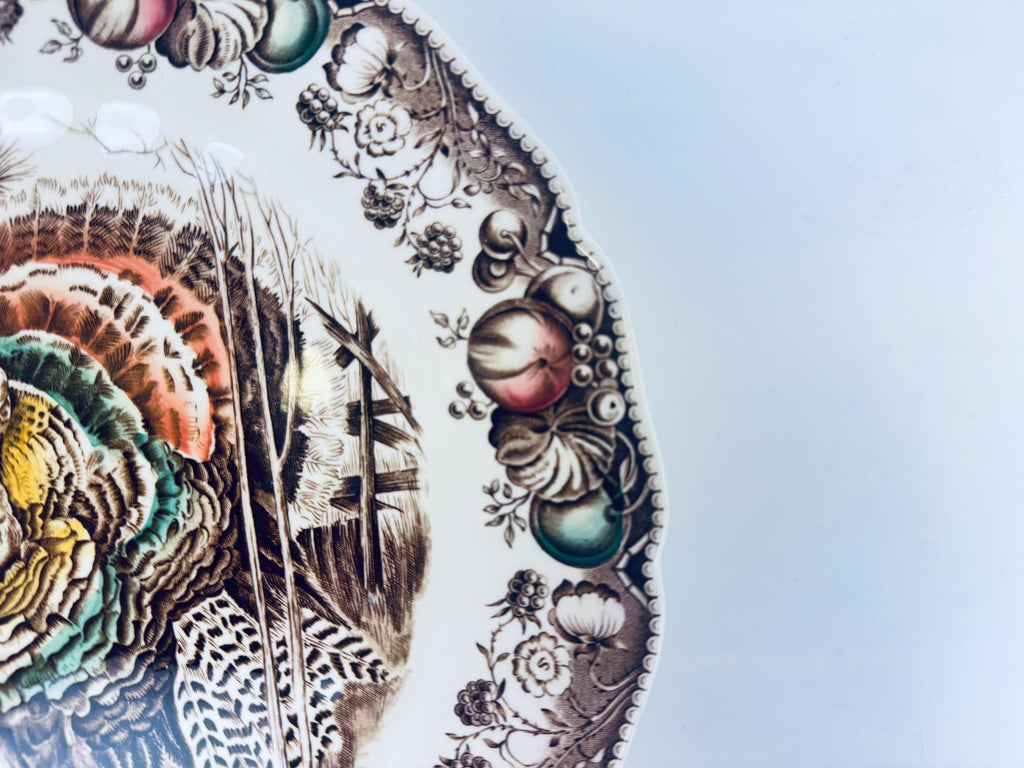 Decorative plate with intricate designs of feathers and spherical elements on a light blue background