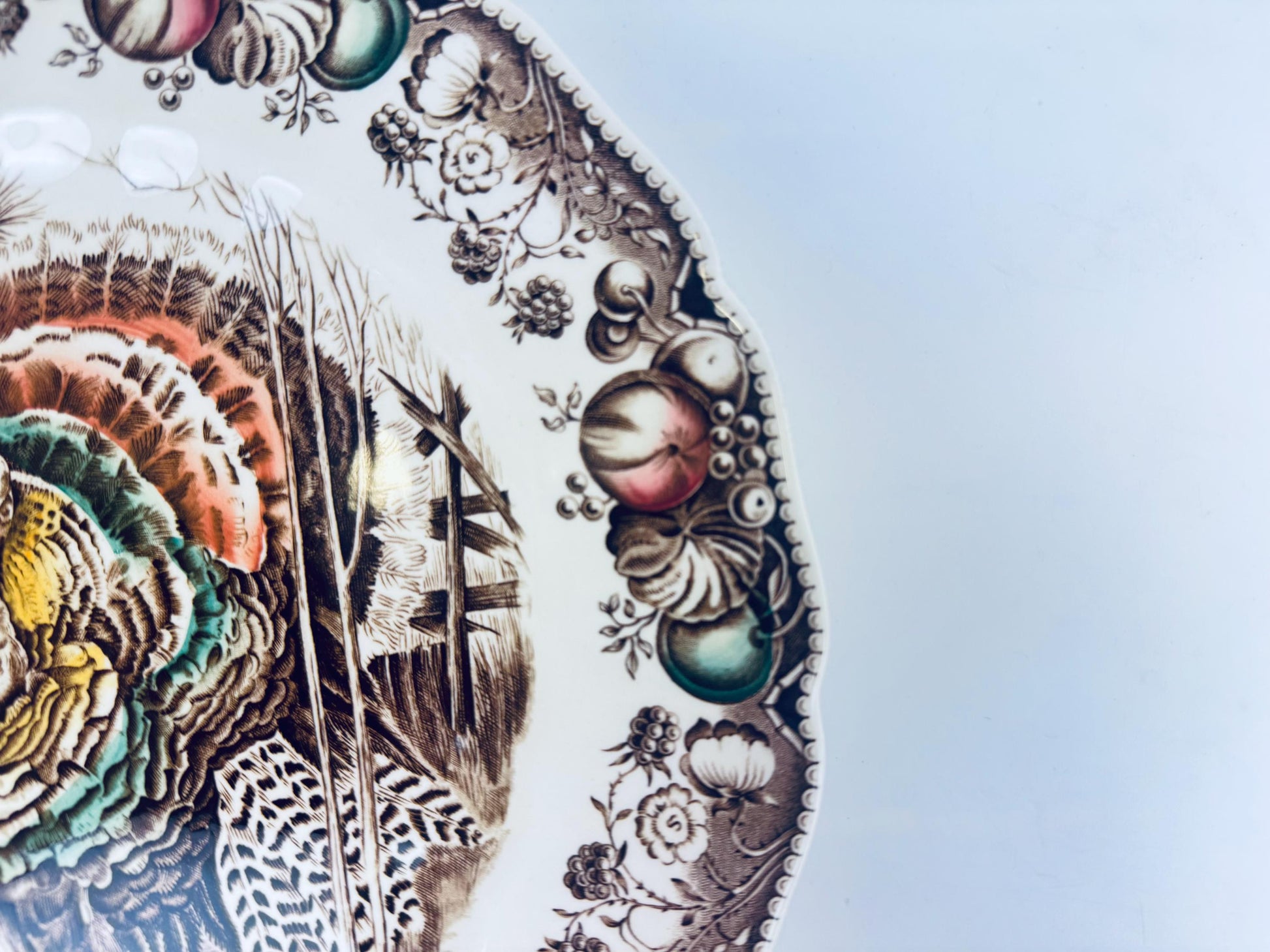 Decorative plate with intricate designs of feathers and spherical elements on a light blue background