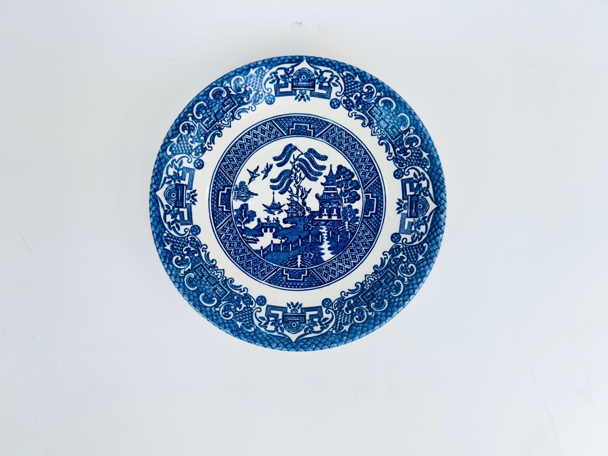 Blue and white decorative saucer plate on a light gray background
