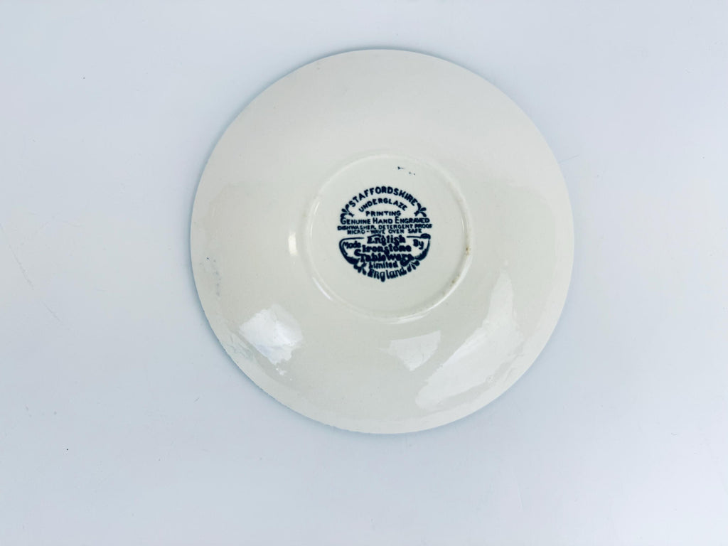 White ceramic plate with blue text on a light gray background