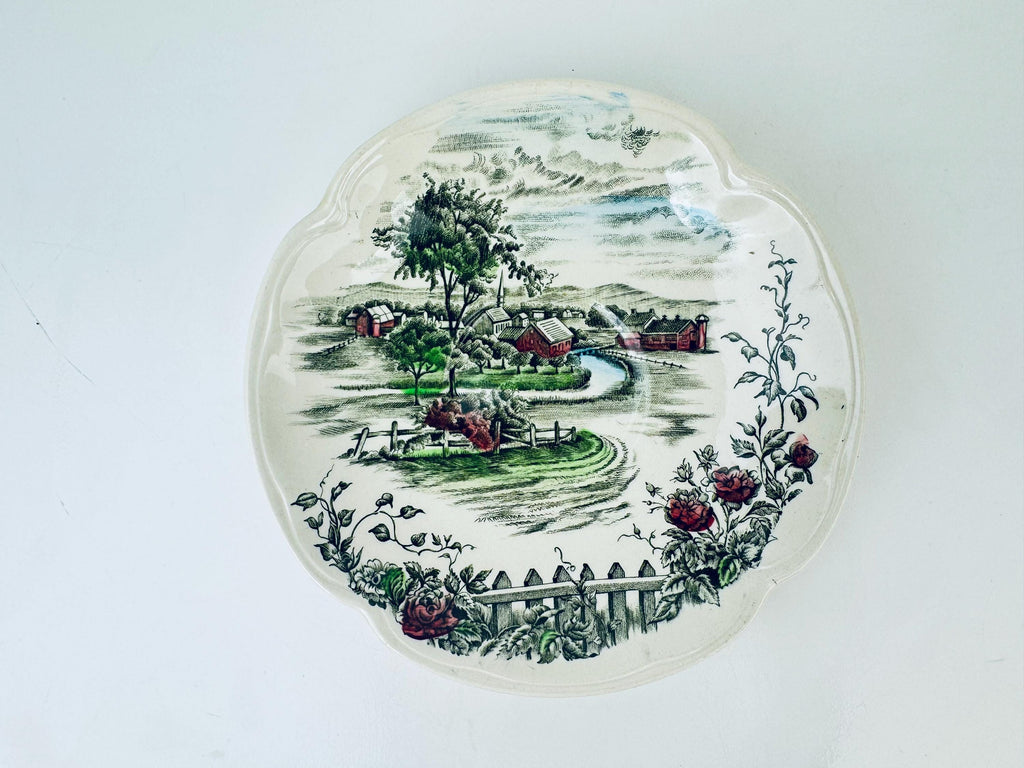 Decorative saucer plate with a scenic landscape design on a white background