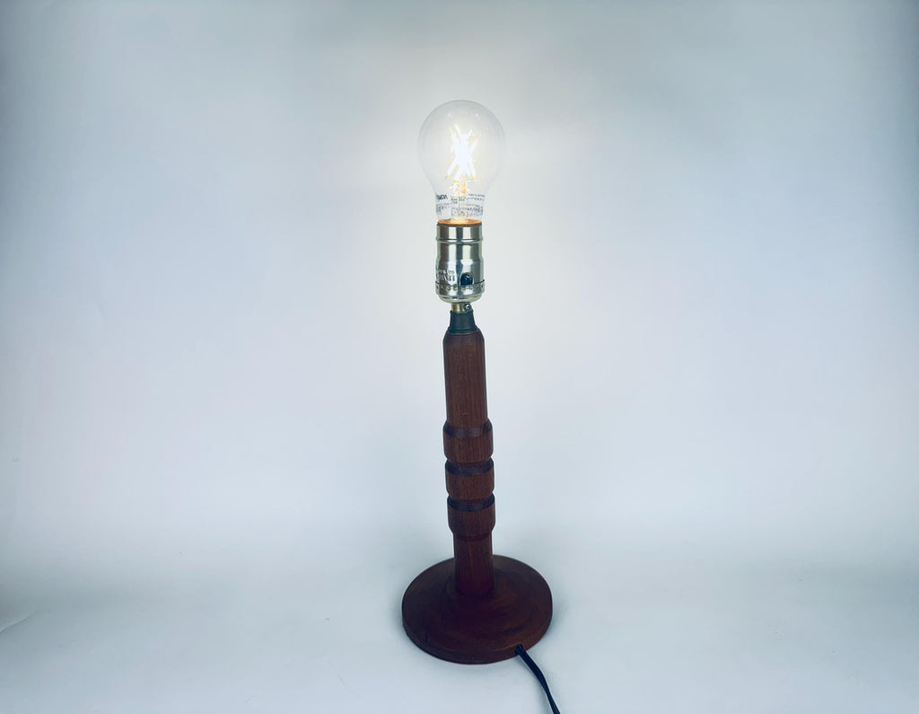 Wooden lamp with a lit bulb on a white background