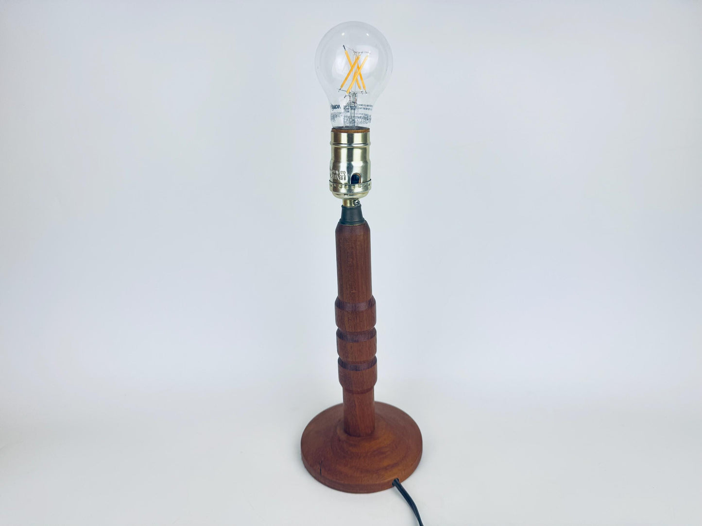 Wooden lamp with a clear light bulb on a white background