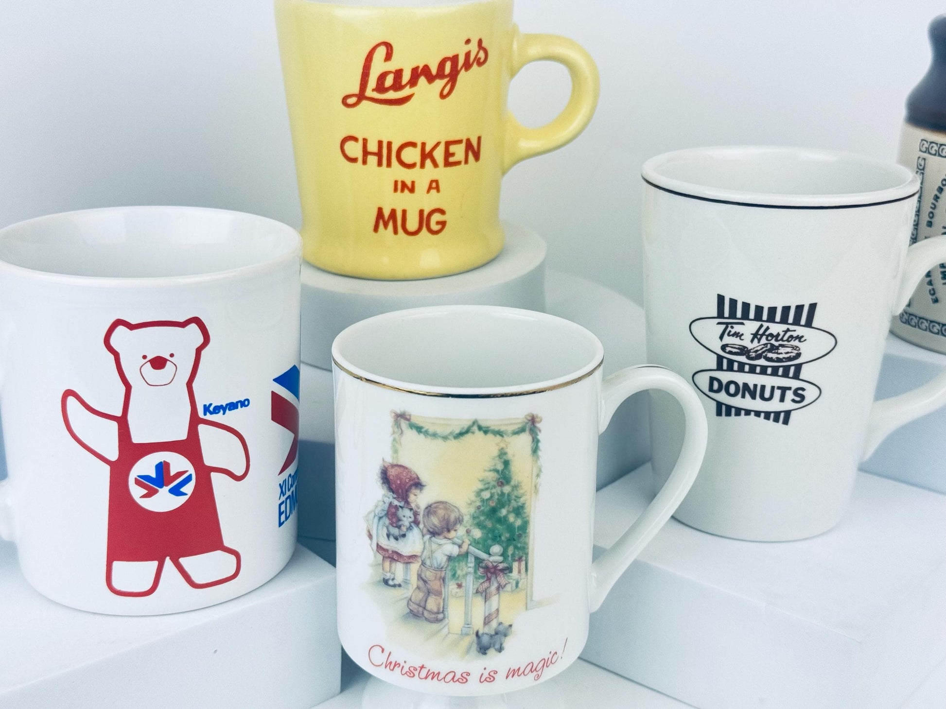Collection of mugs with various designs and text on a white surface