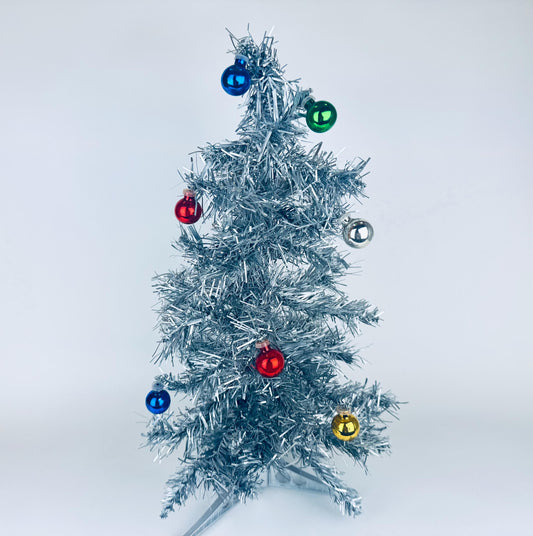 Silver tinsel Christmas tree with colorful ornaments on a white background