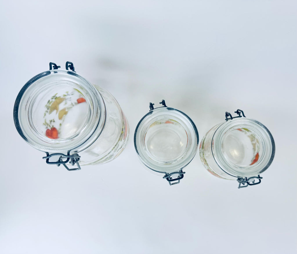 Three glass jars with metal clamps on a white background