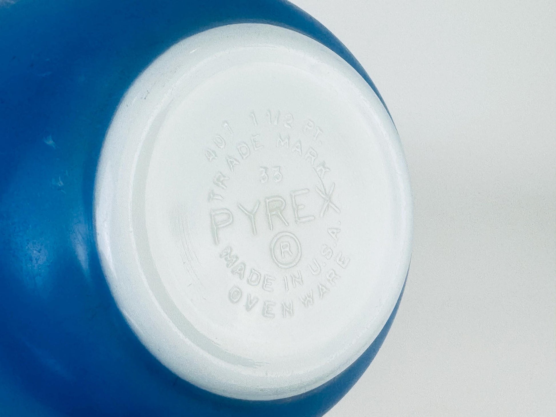 Close-up of a Pyrex brand label on a blue glass bowl.