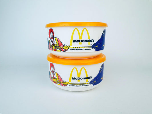 Two McDonald's-themed containers with colorful designs on a light gray background