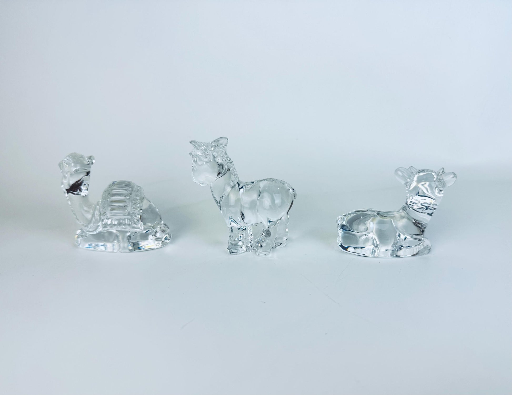 All three crystal nativity animals — cow, donkey, camel — arranged together on white background